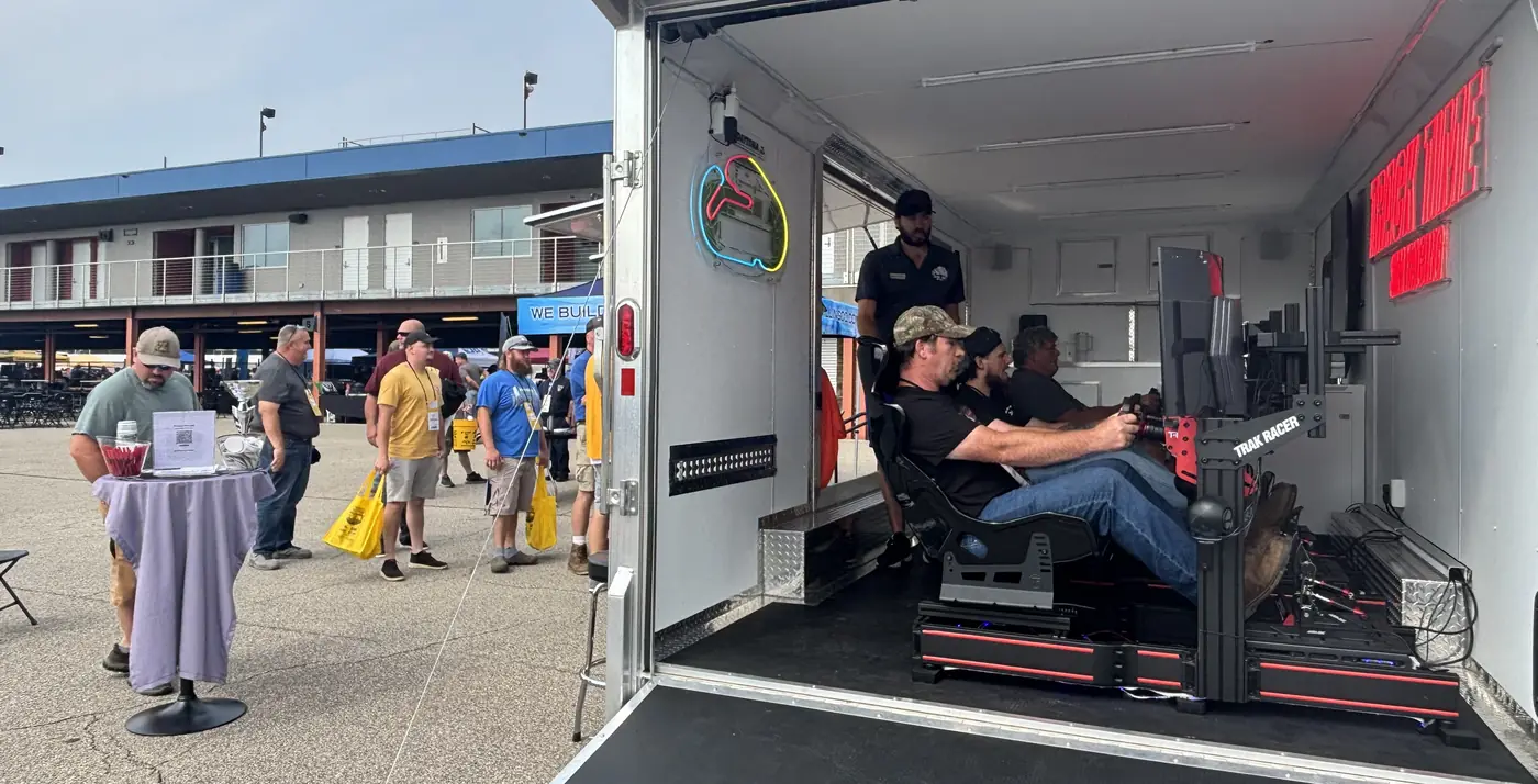 Race fans trying the simulators inside the trailer at Michigan International Speedway