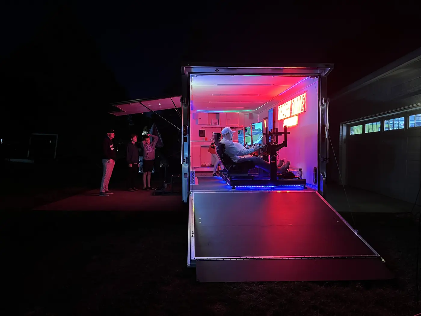 The trailer open after dark with a racer inside