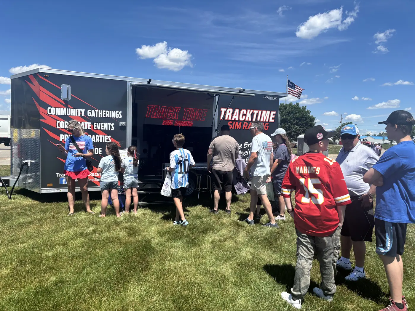 A crowd lined up at the Track Time trailer at an outdoor event