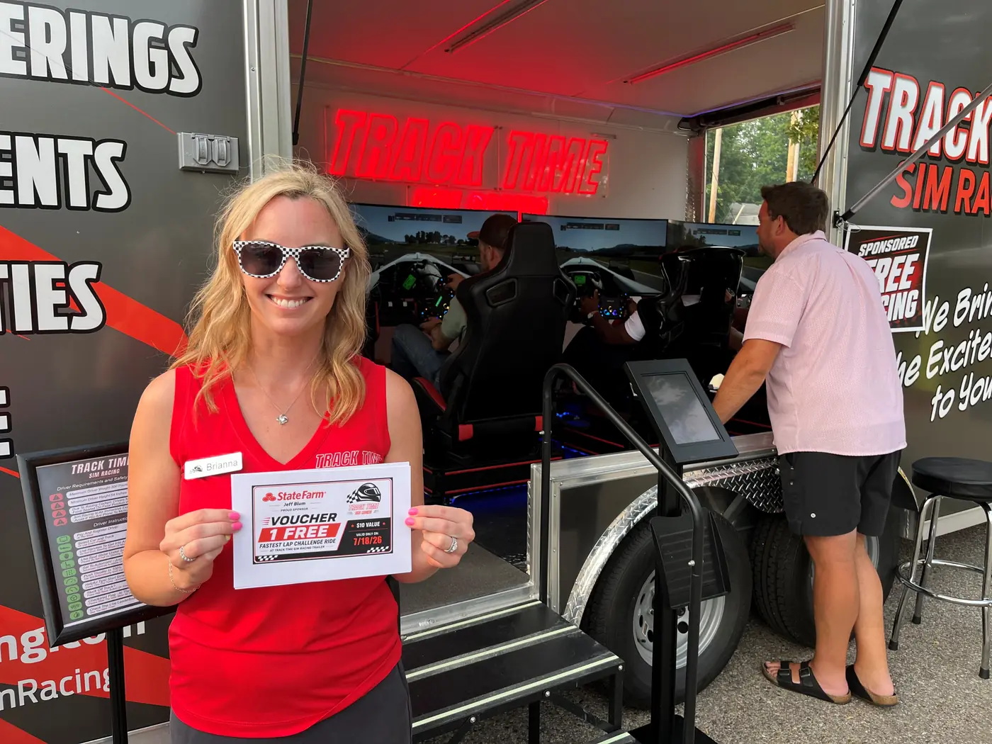 A winner holding a prize certificate in front of the trailer